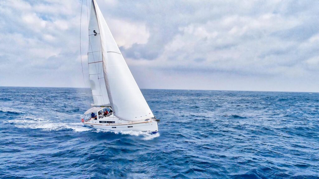 2018 Beneteau Oceanis 45 sailing on open sea under cloudy skies.