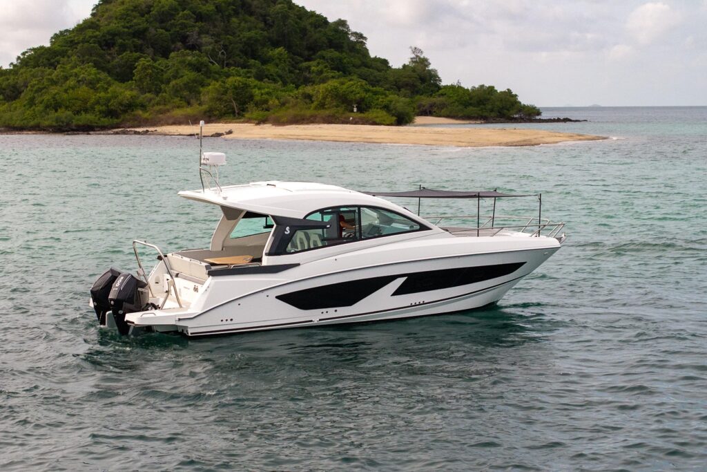 2025 Beneteau Gran Turismo 32 yacht cruising near a lush island.