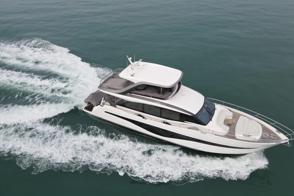 Luxury yacht cruising on the water, leaving a white wake.