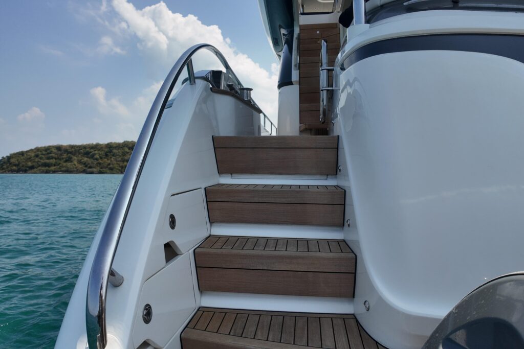 Yacht stairs with teak steps leading to the deck, ocean view. La Mer.