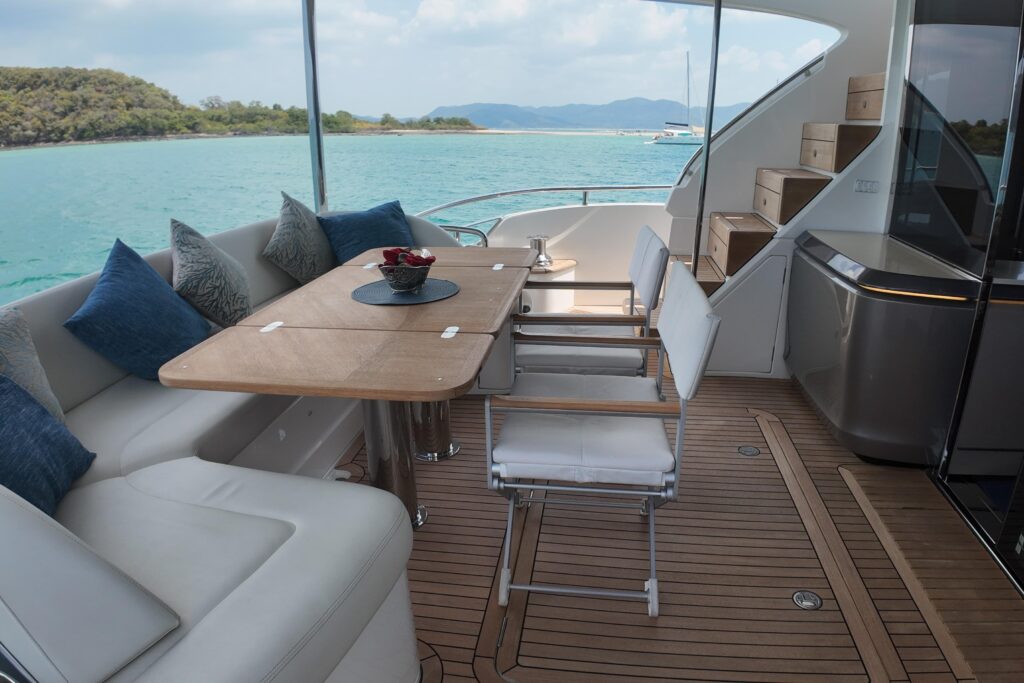 Luxury yacht deck with dining area and ocean view.