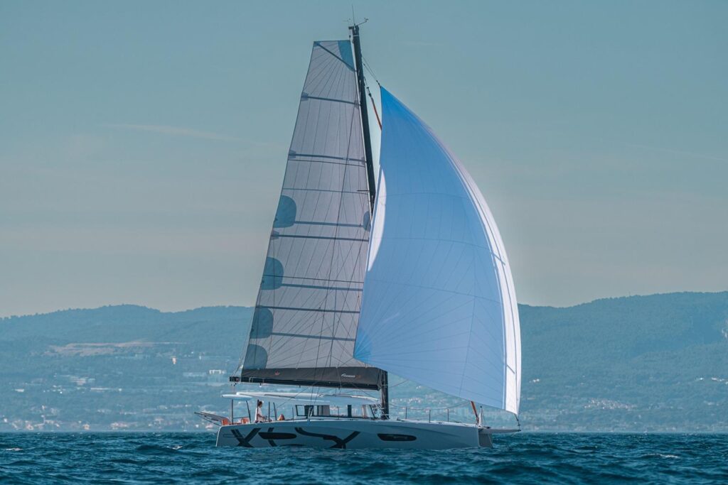 Manufacturer Provided Image: 2026 Excess 13 sailboat cruising on open water with mountains in the background.