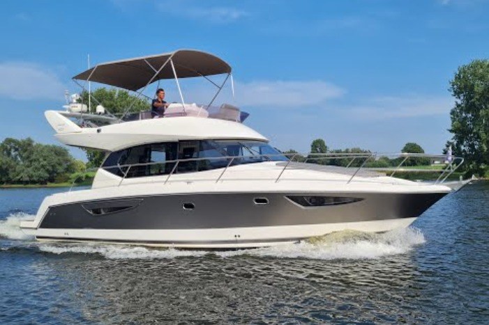 2011 Prestige 400 yacht cruising on a calm river under a clear blue sky.
