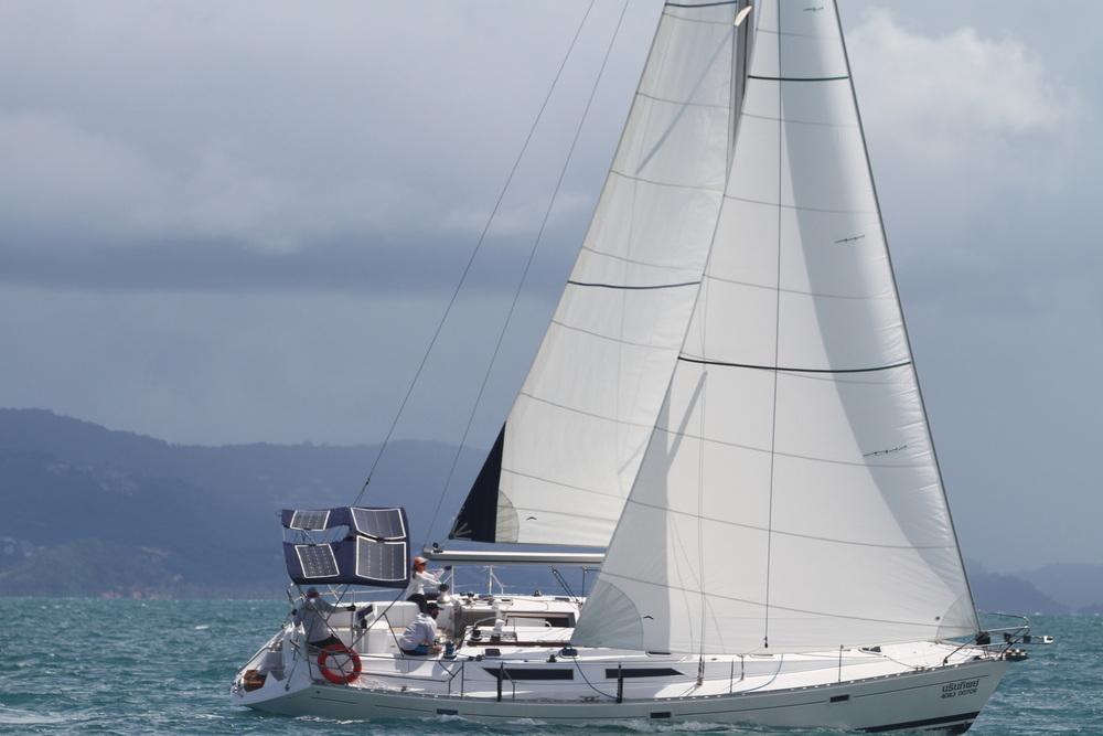 1995 Jeanneau Sun Odyssey sailboat with solar panels on open sea.